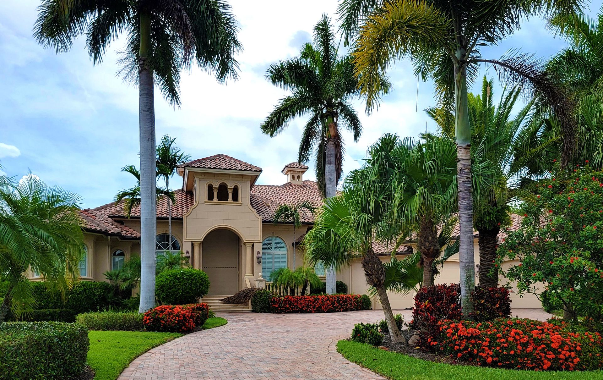 Elegant mansion with lush palm trees and landscaped garden, perfect for luxury living.